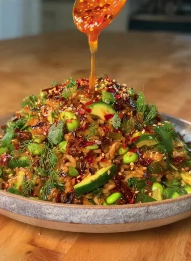 Delicious bowl of Crispy Rice Salad decorated with fresh vegetables and herbs.