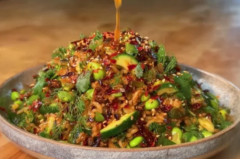 Delicious bowl of Crispy Rice Salad decorated with fresh vegetables and herbs.