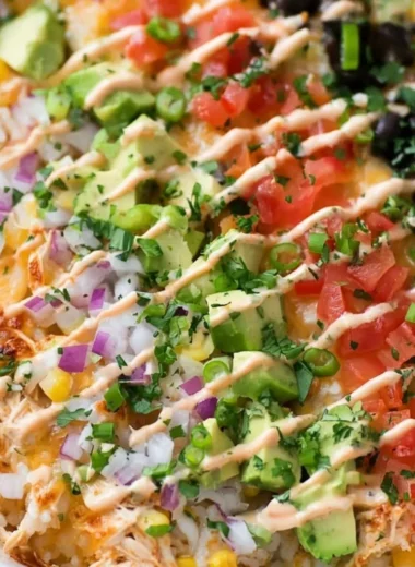 Healthy chicken burrito casserole topped with cheese and fresh ingredients