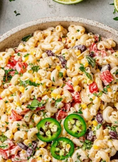 Colorful bowl of Mexican Macaroni Salad with fresh vegetables and spices.