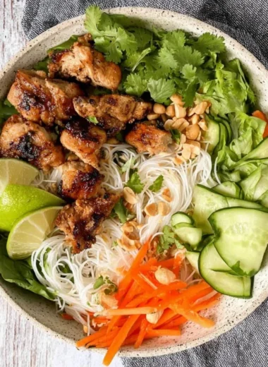 Vietnamese noodle bowl with lemongrass chicken, fresh herbs, and vegetables