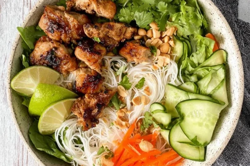 Vietnamese noodle bowl with lemongrass chicken, fresh herbs, and vegetables