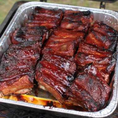 Delicious BBQ ribs served on a platter with barbecue sauce and sides