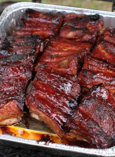 Delicious BBQ ribs served on a platter with barbecue sauce and sides