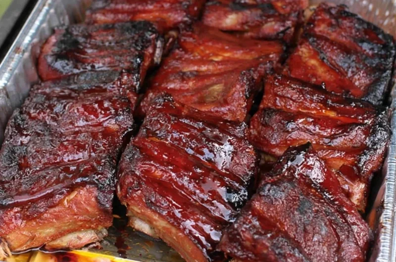 Delicious BBQ ribs served on a platter with barbecue sauce and sides