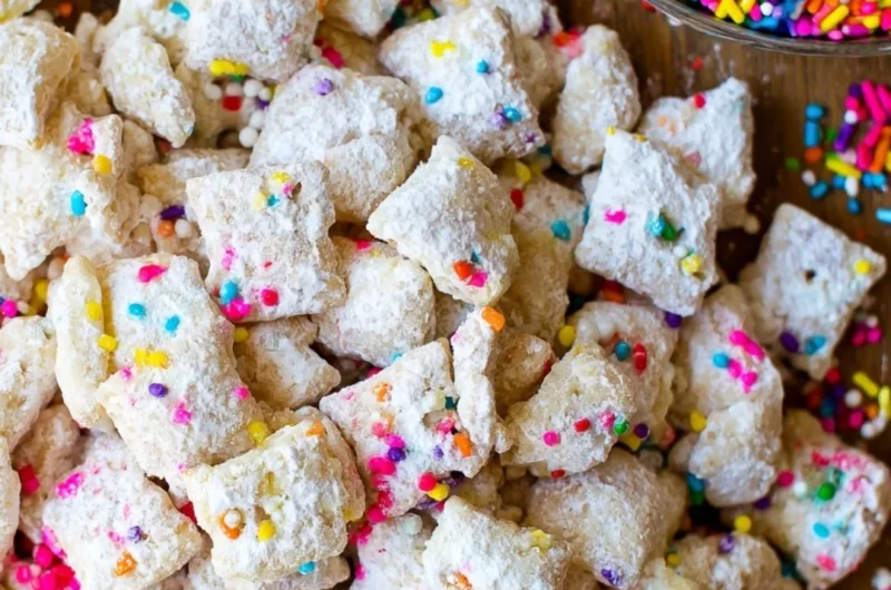 Bowl of delicious Cake Batter Puppy Chow with colorful sprinkles