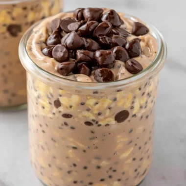 Bowl of chocolate protein overnight oats topped with berries and nuts