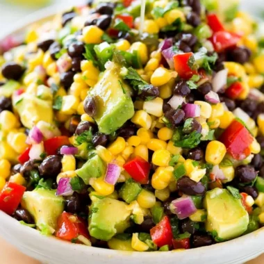 Bowl of vibrant Cowboy Caviar salad with beans, corn, and tomatoes.