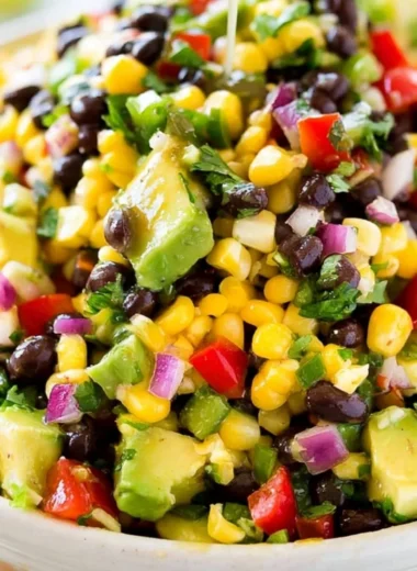 Bowl of vibrant Cowboy Caviar salad with beans, corn, and tomatoes.