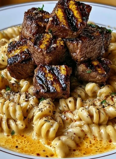 Creamy garlic butter steak bites served with spicy Cajun Alfredo twisted pasta dish