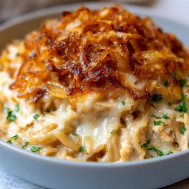 French onion chicken orzo casserole baked in a dish with melted cheese on top.