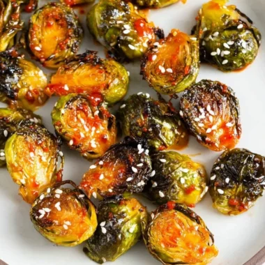 Gochujang roasted Brussels sprouts served in a bowl garnished with sesame seeds