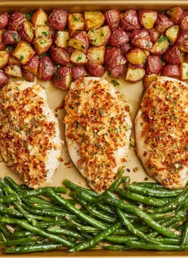 Delicious Parmesan Crusted Chicken on a sheet pan with vegetables.