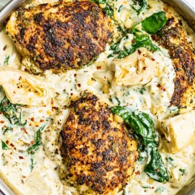 Delicious spinach artichoke chicken skillet topped with cheese.
