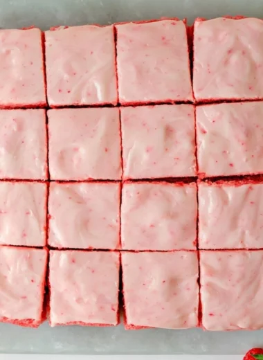 Delicious strawberry brownies topped with creamy frosting on a plate