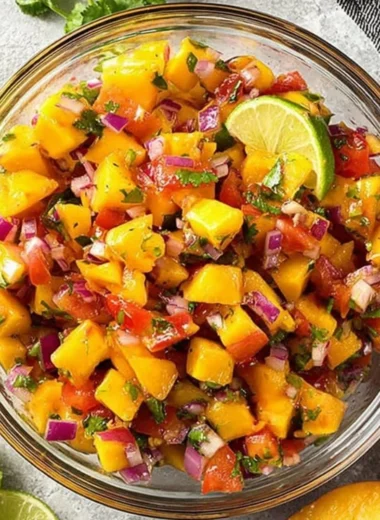 A bowl of sweet and spicy peach salsa with fresh ingredients