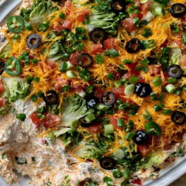 Cottage cheese taco dip served with tortilla chips on a colorful plate.