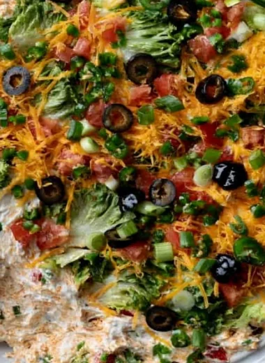 Cottage cheese taco dip served with tortilla chips on a colorful plate.