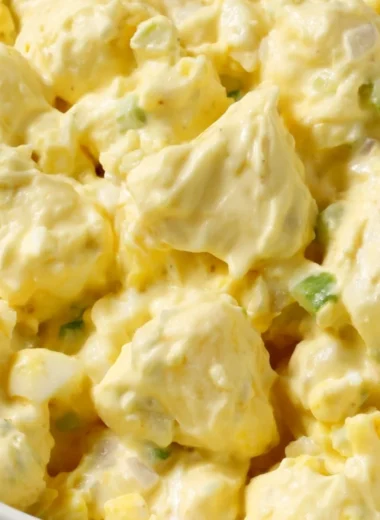 Bowl of creamy potato salad with fresh herbs and vegetables