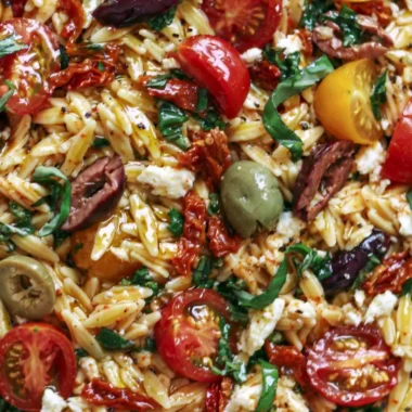 Greek Orzo with tomatoes, olives, basil, and feta served in a bowl