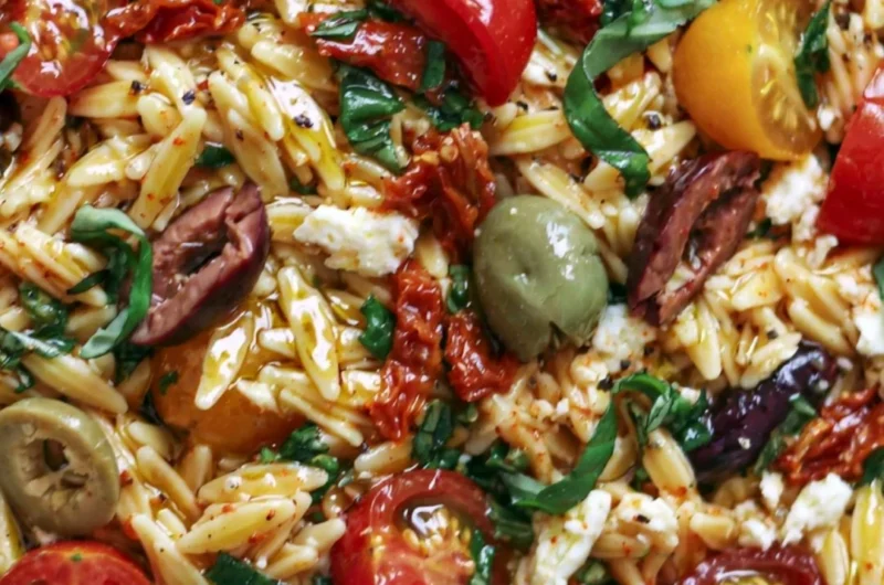 Greek Orzo with tomatoes, olives, basil, and feta served in a bowl