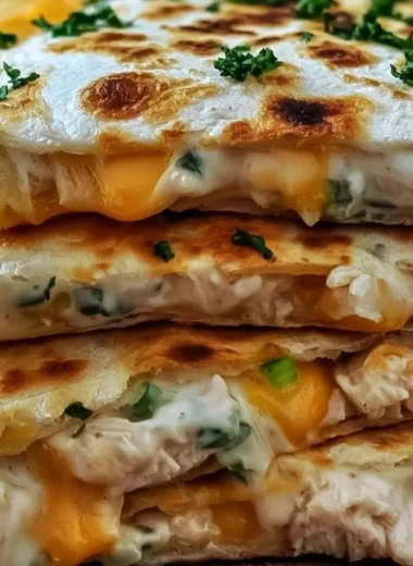 High-protein chicken ranch quesadilla on a plate, garnished with fresh toppings.