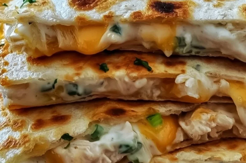 High-protein chicken ranch quesadilla on a plate, garnished with fresh toppings.