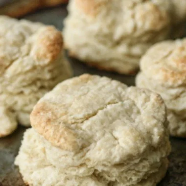 Freshly baked homemade buttery biscuits on a wooden table