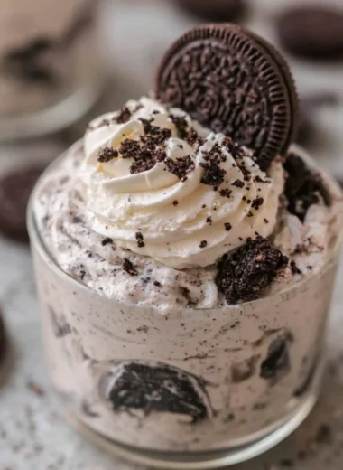 No bake Oreo cheesecake cups topped with crushed Oreos and whipped cream