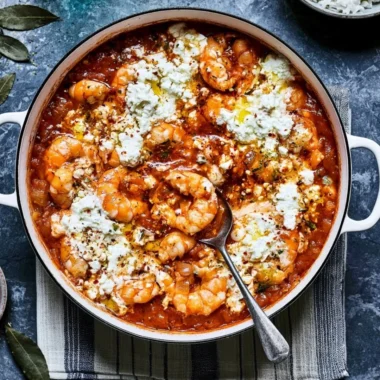 Delicious Prawn Saganaki served in a traditional dish with feta cheese and herbs