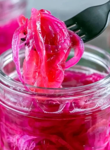 Quick pickled red onions in a jar with vibrant colors and flavors.