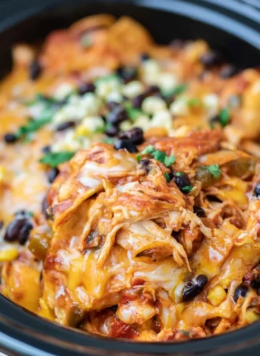 Delicious slow cooker chicken enchiladas topped with cheese and salsa