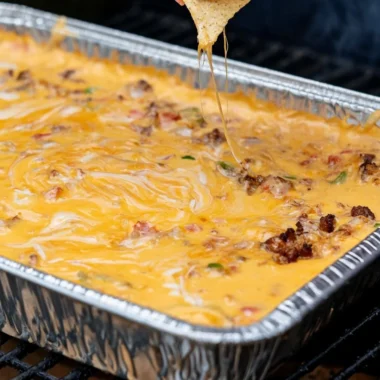 Delicious smoked queso dip in a bowl with tortilla chips.