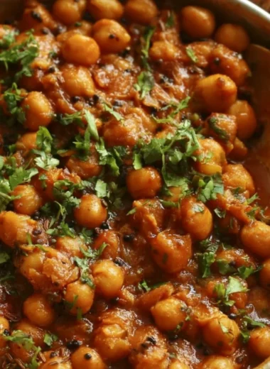 Bowl of chickpea masala with spices and herbs, a flavorful vegetarian dish