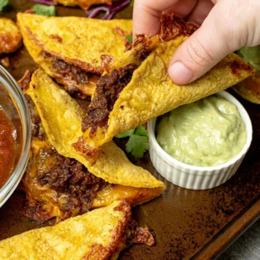 Crispy beef tacos topped with fresh ingredients and served on a plate